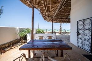 drewniany stół w pokoju z widokiem na ocean w obiekcie Beachfront Villa Patti ZanzibarHouses w mieście Kiwengwa