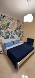 una camera da letto con un letto con lenzuola blu e carta da parati di Raggio di Sole a Gaeta