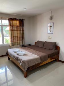 1 dormitorio con 1 cama con 2 toallas en Klang Muang River Home, en Phetchabun