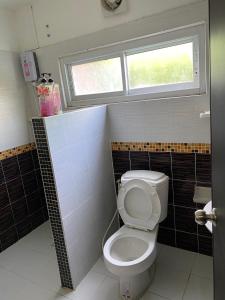 a bathroom with a toilet and a window at Klang Muang River Home in Phetchabun