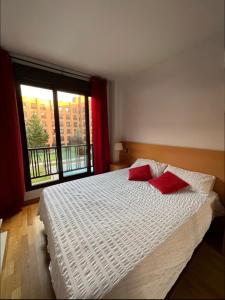 a bedroom with a bed with two red pillows on it at Samaniego suite, AirPort, ifema turístico in Madrid +25 photos