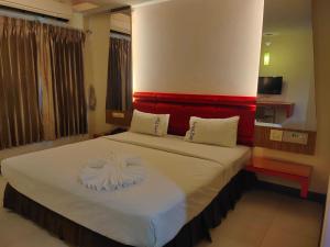 Un dormitorio con una cama grande con cabecero rojo. en เพอร์เฟลคเพลช (Perfect Place Hotel), en Ban Khlong Phruan