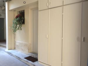 a room with white cabinets and a plant on the wall at Le Saint Claude in Paris