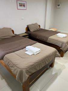 two beds in a room with towels on them at Klang Muang River Home in Phetchabun