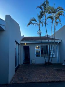 a house with two palm trees in front of it at Goulden Street Guest House in East London