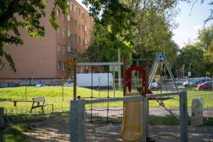 einen Spielplatz in einem Park neben einem Gebäude in der Unterkunft Comfort 28 B in Miskolc