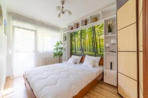 um quarto com uma grande cama branca e uma janela em Comfort 28 B em Miskolc