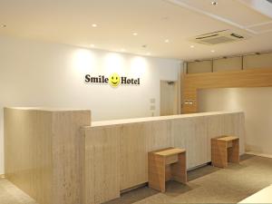 熊谷市にあるスマイルホテル熊谷の壁に看板が貼られた笑顔のホテルロビー