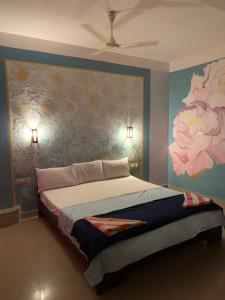 a bedroom with a large bed with a painting on the wall at Marina guest house in Kovalam