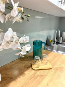 a pair of glasses sitting on a counter with flowers at Batalionów Apartment in Warszawa