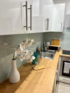 a kitchen counter with a vase with flowers in it at Batalionów Apartment in Warszawa