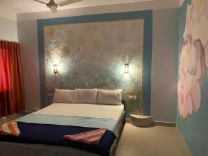 a bedroom with a bed with a painting on the wall at Marina guest house in Kovalam