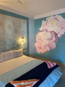 a bedroom with a painting of flowers on the wall at Marina guest house in Kovalam