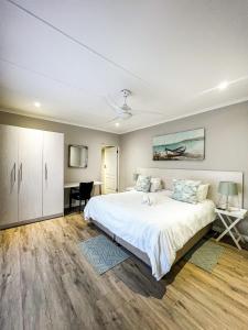 1 dormitorio con 1 cama blanca grande y escritorio en Goulden Street Guest House, en East London
