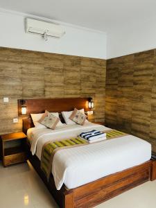 ein Schlafzimmer mit einem großen Bett mit Holzwänden in der Unterkunft Kastapar Bridge Lembongan in Nusa Lembongan