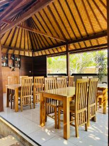 einen Holztisch und Stühle unter einem Pavillon in der Unterkunft Kastapar Bridge Lembongan in Nusa Lembongan