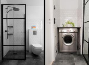 a bathroom with a toilet and a washing machine at Industrial Luxury City Loft in Gothenburg