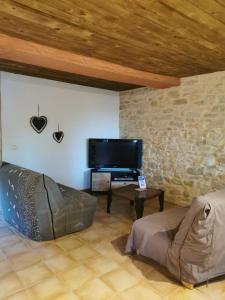 a living room with a tv and a couch and a table at Gîte M in Codognan