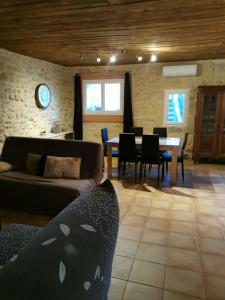 a living room with a couch and a table and chairs at Gîte M in Codognan