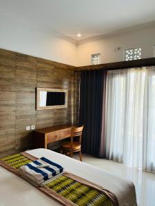 Schlafzimmer mit einem Schreibtisch, einem Bett und einem Tisch in der Unterkunft Kastapar Bridge Lembongan in Nusa Lembongan + 12 Fotos