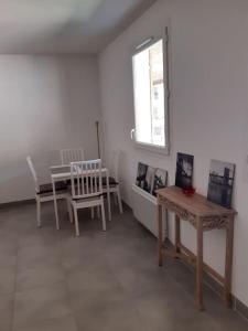 Habitación con mesa, sillas y ventana en Appartement avec parking en résidence 4 personnes 15min plage, en Sète