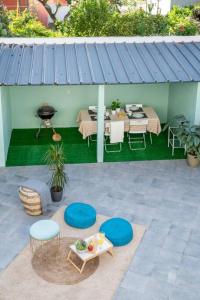un patio con mesa, sillas y parrilla en Villa Turquesa Estoril, en Alcabideche