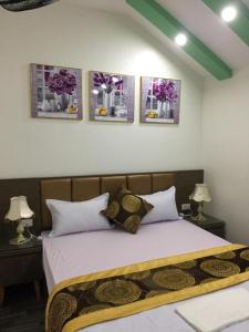 1 dormitorio con 1 cama con 4 cuadros en la pared en Ánh Sao Hotel - ngõ 42 Liễu Giai - by Bay Luxury, en Hanói