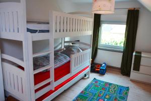 a bedroom with two bunk beds and a window at Ferienhaus am Nationalpark Eifel in Dreiborn