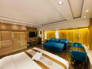 a hotel room with two beds and a blue couch at Home2 Renaissance Club in Mumbai