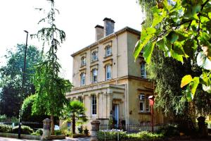 uma casa velha com uma cerca em frente em Victoria Square Hotel Clifton Village em Bristol