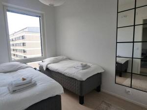 2 aparte bedden in een kamer met een raam bij Hotellitasoinen, uusi huoneisto! in Tampere