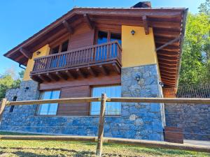a log cabin with a balcony on top of it at Els Tres Sols in Camprodon