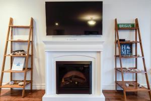 a fireplace with a television on top of it at Belle Vue Cottage - Upper Island Cove in Upper Island Cove