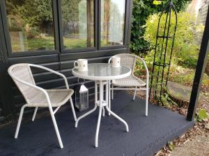 una mesa blanca y 2 sillas en un porche en Luxury Self Catering in Colchester, en Colchester