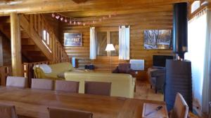 a living room with a table and chairs and a couch at CHALET DE L'OURS in Saint-Pierre-dels-Forcats