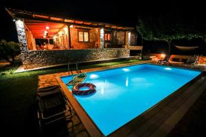 a swimming pool in front of a house at night at villa fairytale in Nerotriviá