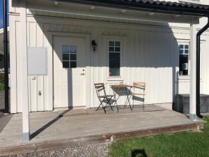 a patio with two chairs and a table on a house at Ett rum & kök in Bålsta