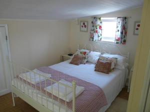 Un dormitorio con una cama blanca con almohadas y una ventana en Casa Flora Loft Studio, en Sauzal