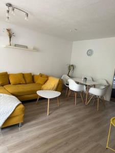 a living room with a yellow couch and tables at Ferienwohnung Sunny in Bad Dürrheim