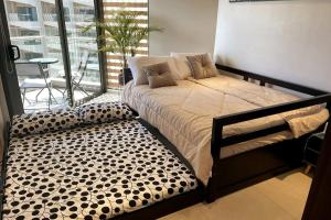 una camera con un grande letto e un balcone di Dominiks Elegant Apt Ocean Views, Pool at Tambuli Resort 10 Floor a Maribago