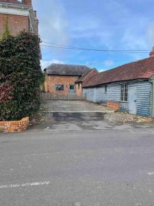 una strada vuota di fronte a due edifici in mattoni di Annex at Southfields in idyllic Hampshire village a Greywell