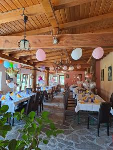 a dining room with tables and chairs and wooden ceilings at Pensiunea Casa Noastra in Baia de Fier