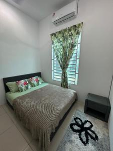 En eller flere senge i et værelse på Aswadhuda Homestay Seri Iskandar