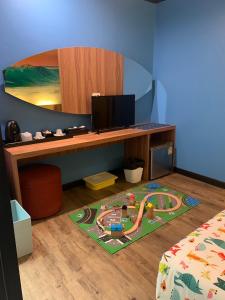 a room with a desk with a toy track on a rug at Must Sea Hotel - SHA Hotel in Kata Beach