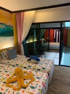 a bedroom with a bed with a stuffed animal on it at Must Sea Hotel - SHA Hotel in Kata Beach