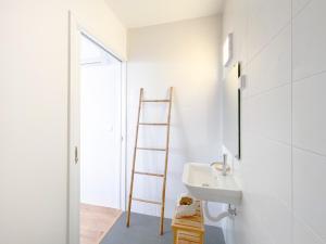 a white bathroom with a sink and a ladder at Pedra do Mar in São Roque