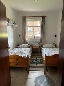 1 dormitorio con 2 camas y ventana en Ferienwohnung Moby Dick, en Ording