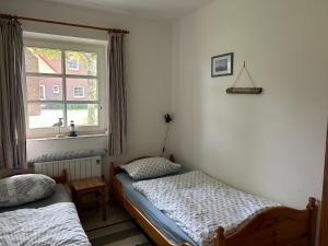 1 dormitorio con 2 camas individuales y ventana en Ferienwohnung Moby Dick, en Ording