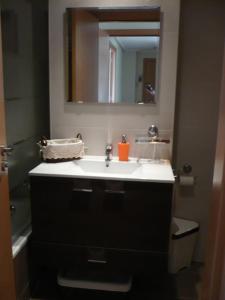 a bathroom with a sink and a mirror at Atico, Piscina, Aire Acondicionado, WI-FI, Parking Gratis, Gran Terraza in Arroyo de la Encomienda