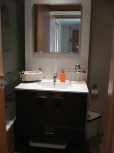 a bathroom with a sink and a mirror at Atico, Piscina, AC, WI-FI y Parking Gratis, Gran Terraza, VUT 47-79 in Arroyo de la Encomienda
